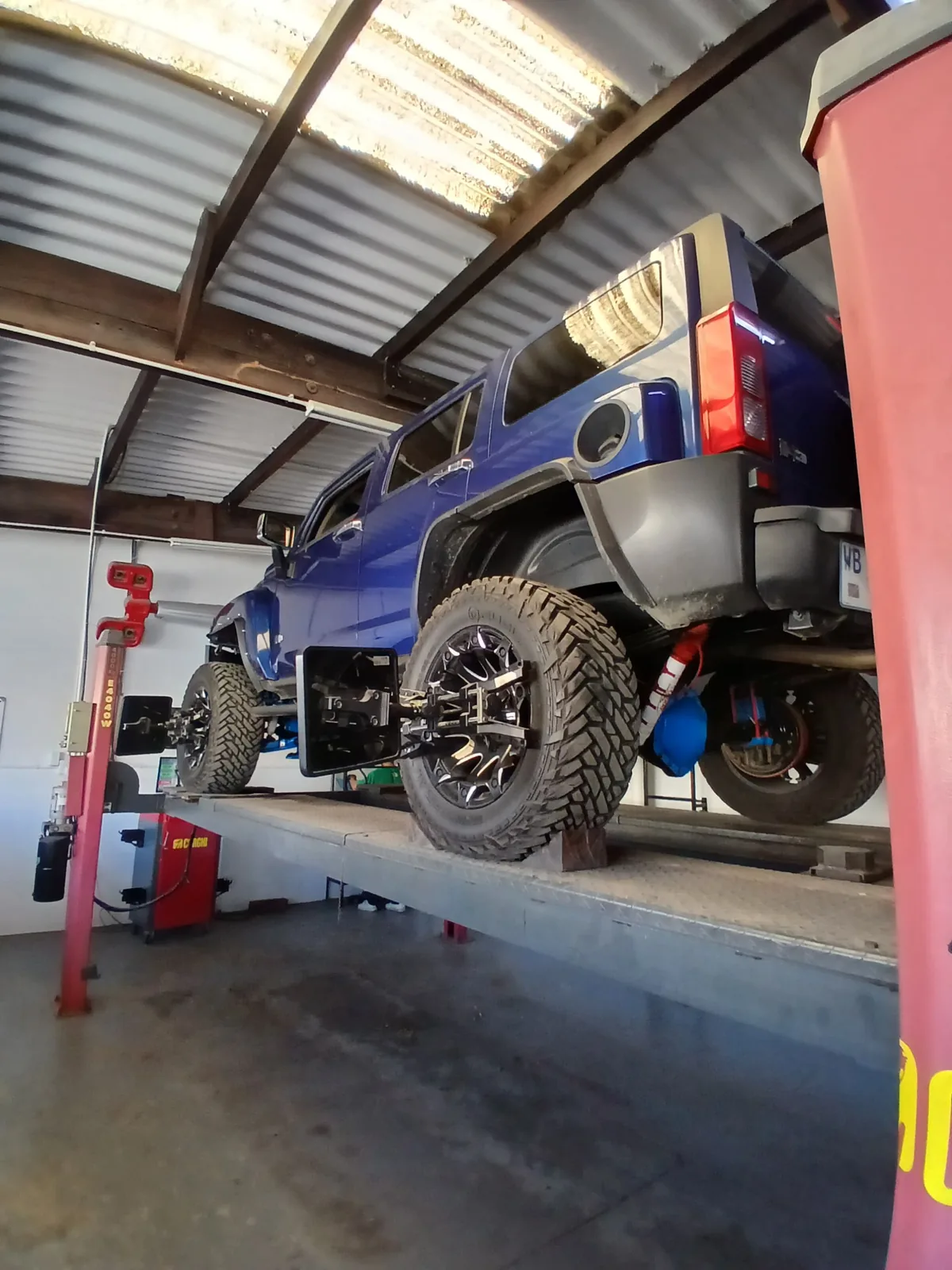 Blue 4x4 raised on a workshop lift